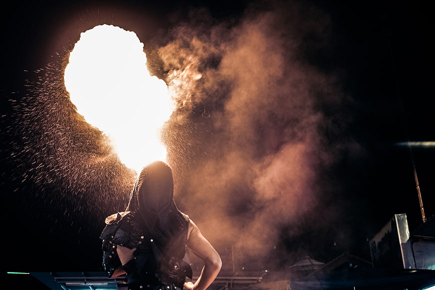 Fire Breather Performing at Night with Flames and Smoke