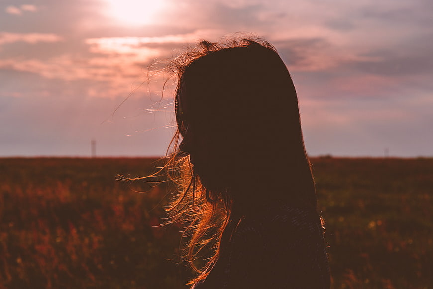 Silhouette of Woman in Field at Sunset