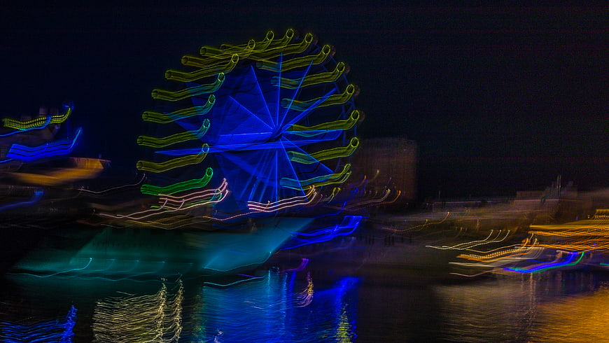 Abstract long exposure light trails of a Ferris wheel at night