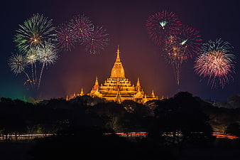 Illuminated Asian Pagoda Temple With Fireworks Display At Night
