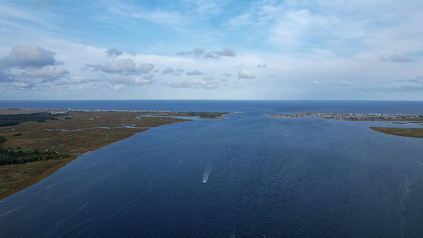 Aerial View of Coastal Waterway with Boat and Marshland