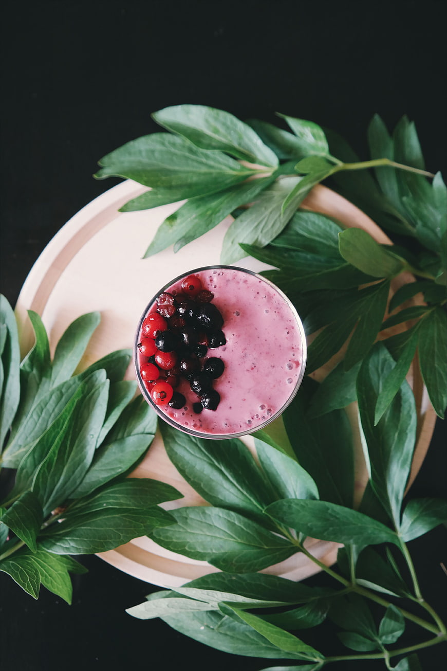 Top View of Berry Smoothie with Fresh Green Leaves