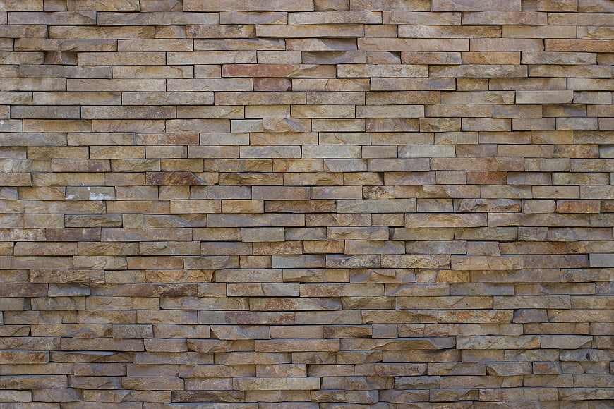 Textured beige stone brick wall background