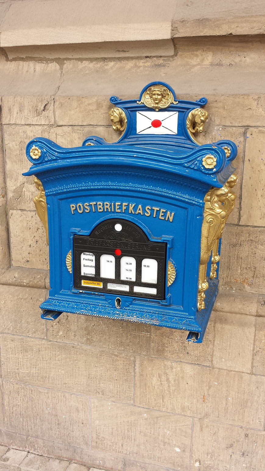 Vintage Blue and Gold Post Box on Stone Wall