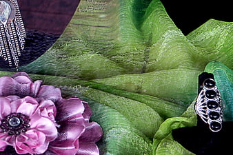 Green textured fabric with pink flower and silver jewelry