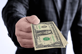 Hand holding one dollar bill in business suit