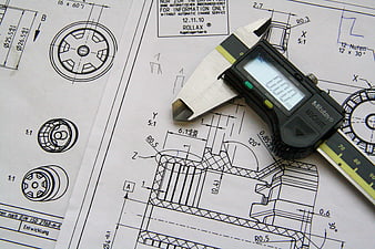 Digital caliper on mechanical engineering blueprint