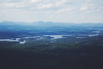 Aerial View of Forested Lakes and Distant Mountains