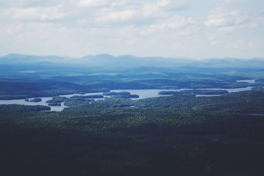 Aerial View of Forested Lakes and Distant Mountains