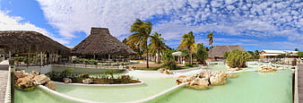 Panoramic View of Tropical Resort with Turquoise Pool and Thatched Cabanas
