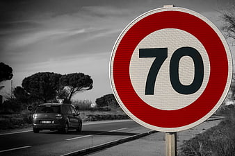 Red 70 Speed Limit Sign on Road with Car