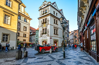 Historic Narrow Building And Vintage Red Car In Prague Old Town Square