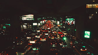 Night traffic jam under city overpass with neon lights