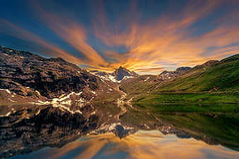 Dramatic Mountain Landscape with Golden Sky and Lake Reflection