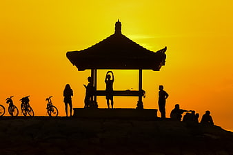 Silhouette of People and Bicycles at Temple Pavilion Sunset