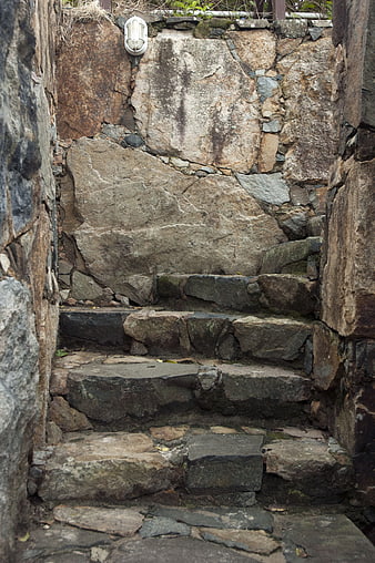 Ancient stone steps leading up a rugged rock wall