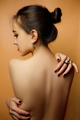 Studio Portrait of Young Woman with Exposed Back and Bun