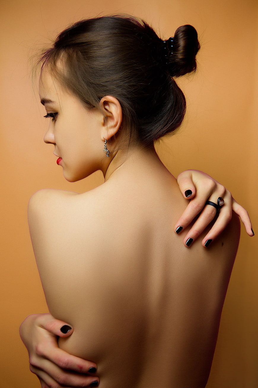 Studio Portrait of Young Woman with Exposed Back and Bun