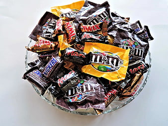Assorted chocolate candies in a clear glass bowl