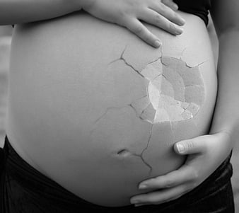 Black and white pregnant belly with cracked texture effect