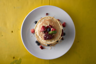 Overhead View of Pancake Stack with Fresh Berries on White Plate
