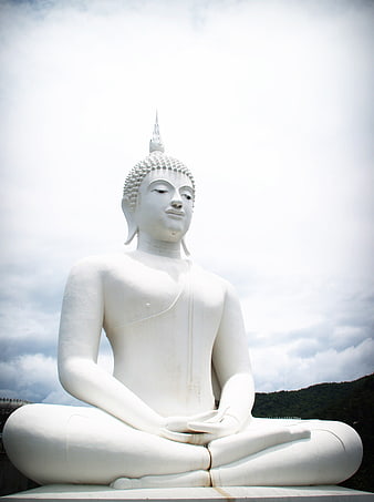 White Buddha Statue Meditating in Lotus Position Against Cloudy Sky