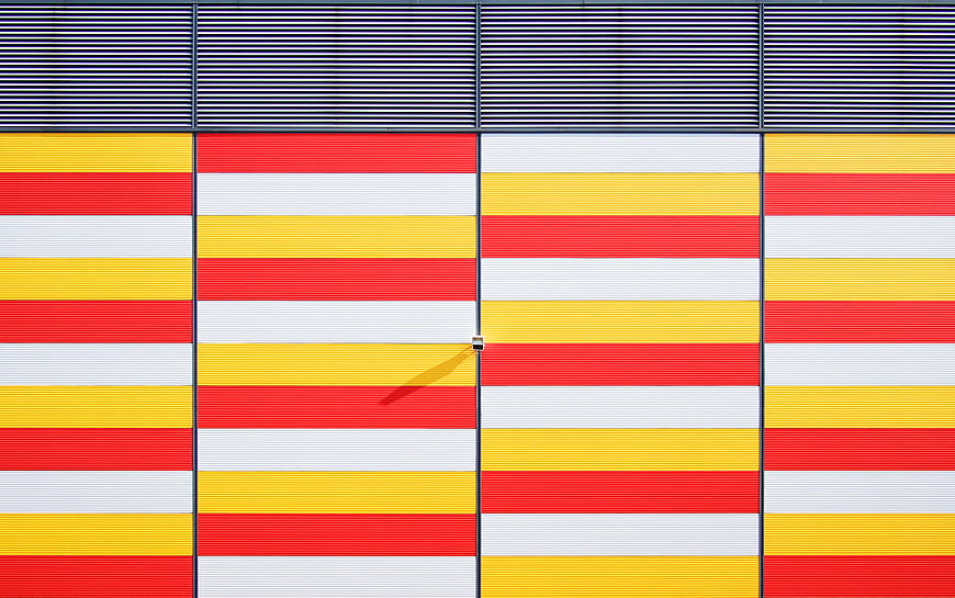 Colorful striped architectural facade with red, yellow, and white panels