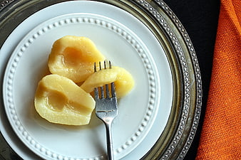 Canned Pears on White Plate with Fork and Silver Charger