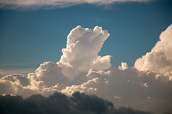 Dramatic cumulus clouds against a deep blue sky