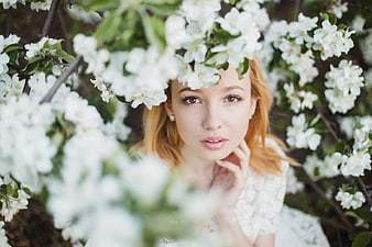 Portrait of young woman with white spring blossoms