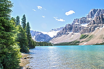 Turquoise Mountain Lake with Pine Forest and Snowy Peaks