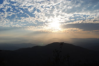 Sunset over layered mountain ranges with dramatic clouds