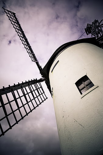 Low angle view of white windmill against dramatic purple sky