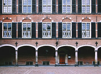 Symmetrical Brick Building with Arches and Shutters