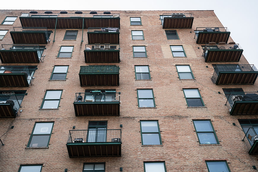 Low Angle View of Brick Apartment Building Facade with Balconies