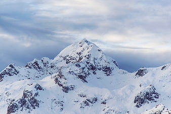 Majestic Snow-Covered Mountain Peak Under Cloudy Sky