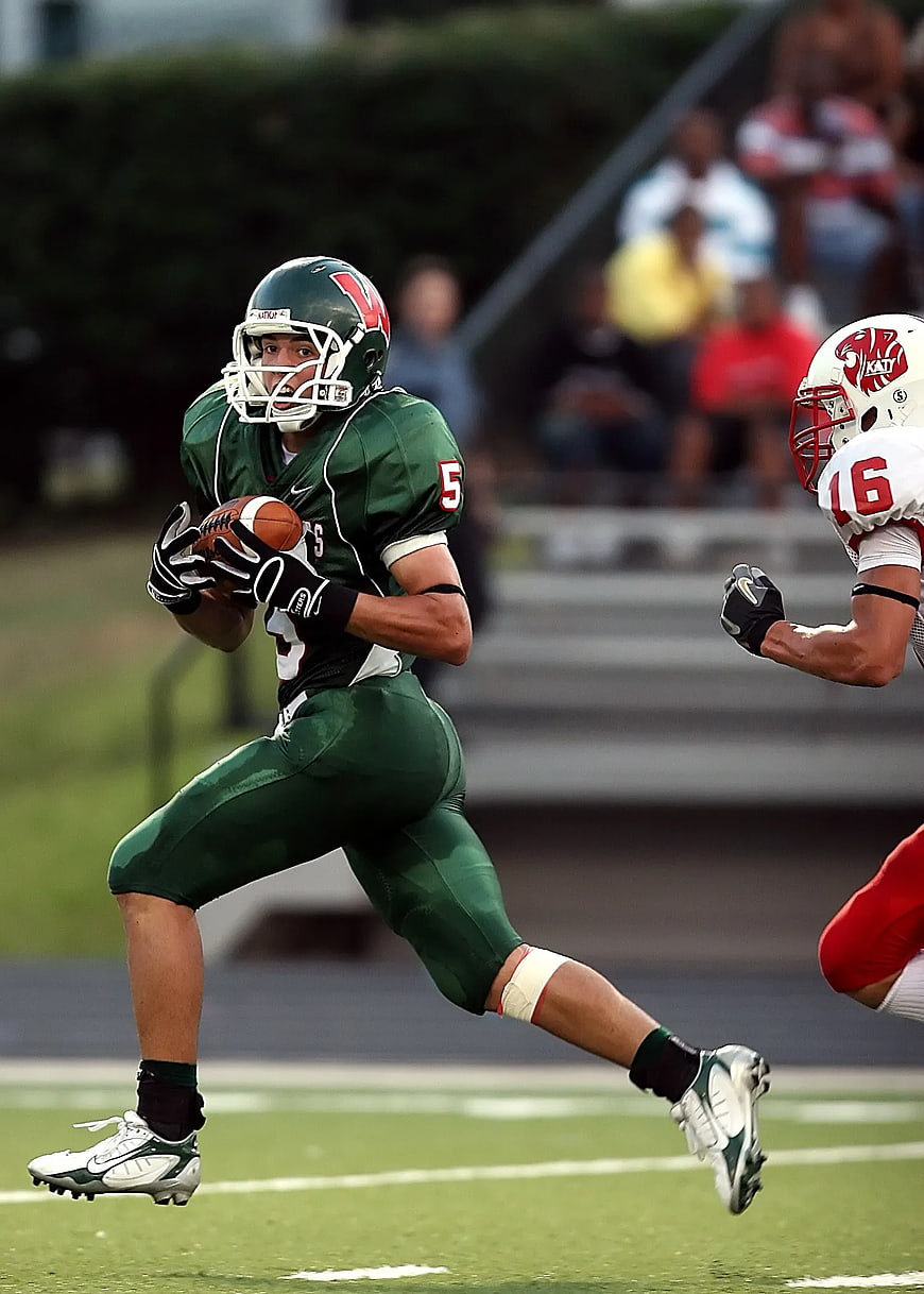 American Football Player Running with Ball in Green Uniform
