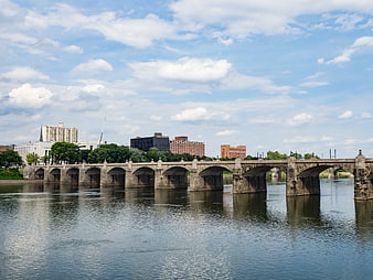 Stone Arch Bridge Over River with City Skyline