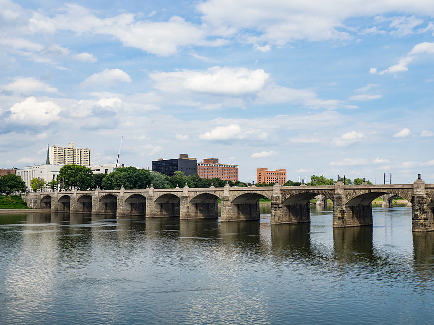 Stone Arch Bridge Over River with City Skyline