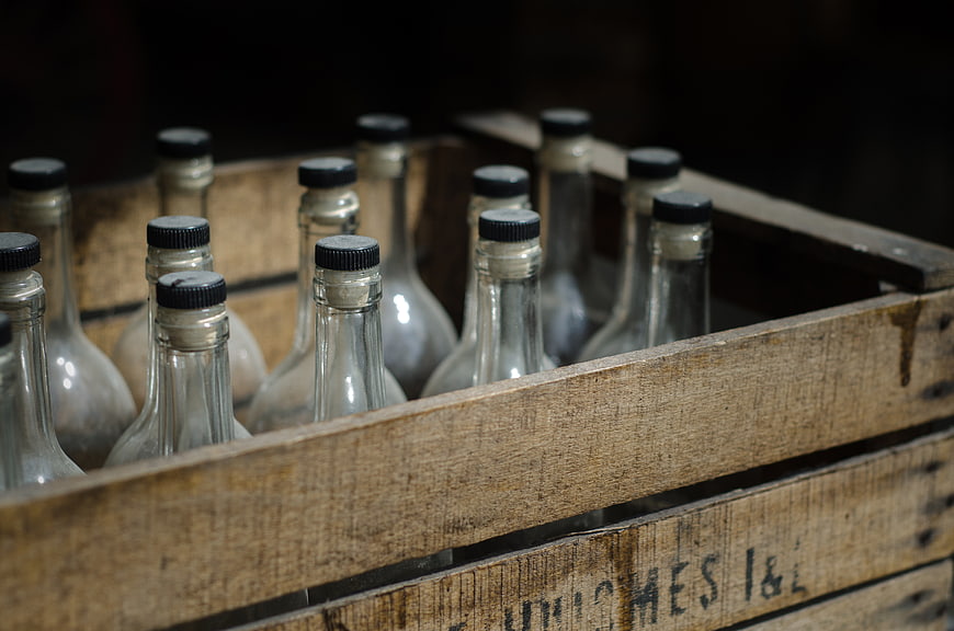Vintage glass bottles in a rustic wooden crate
