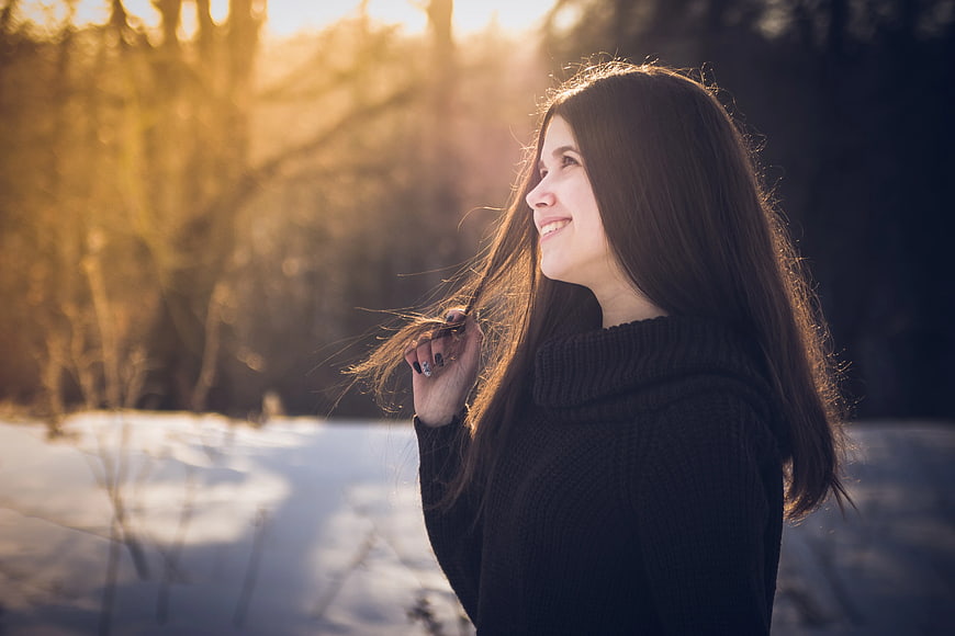 Smiling Woman with Long Hair in Winter Sunset