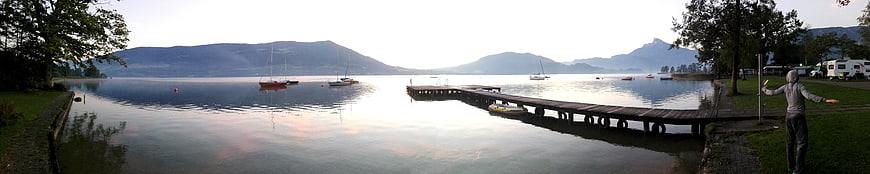 Panoramic Lake View with Wooden Pier and Mountains at Sunrise