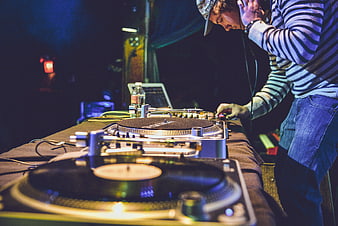 DJ Mixing Vinyl Records at Night Club