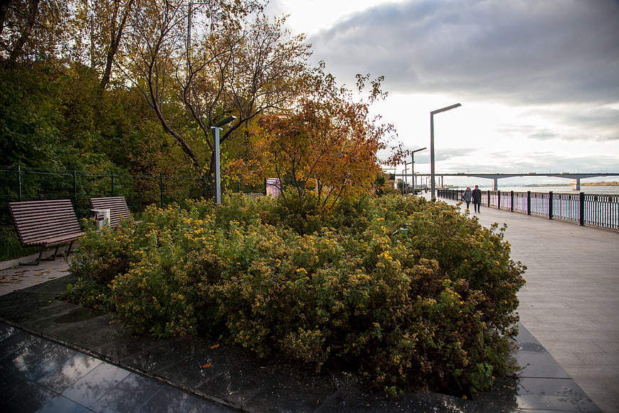 Autumn Riverside Promenade with Walking Couple and Bridge