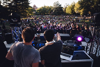 DJs performing live concert for crowd at outdoor festival