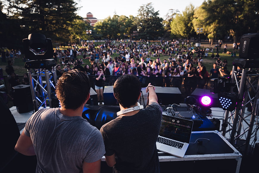 DJs performing live concert for crowd at outdoor festival