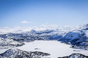 Aerial View of Frozen Lake Surrounded by Snowy Mountains