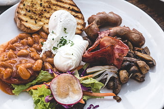 Hearty brunch plate with poached eggs, beans, bacon, and toast