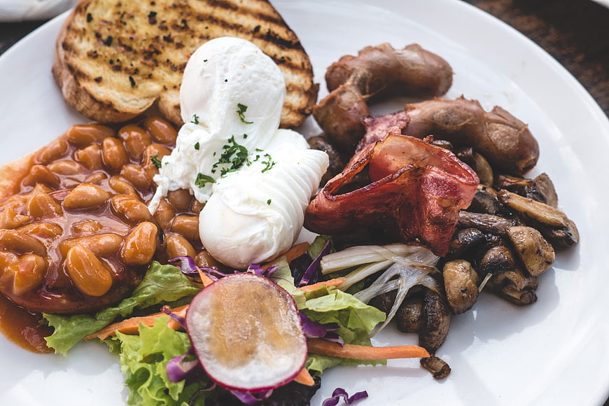 Hearty brunch plate with poached eggs, beans, bacon, and toast