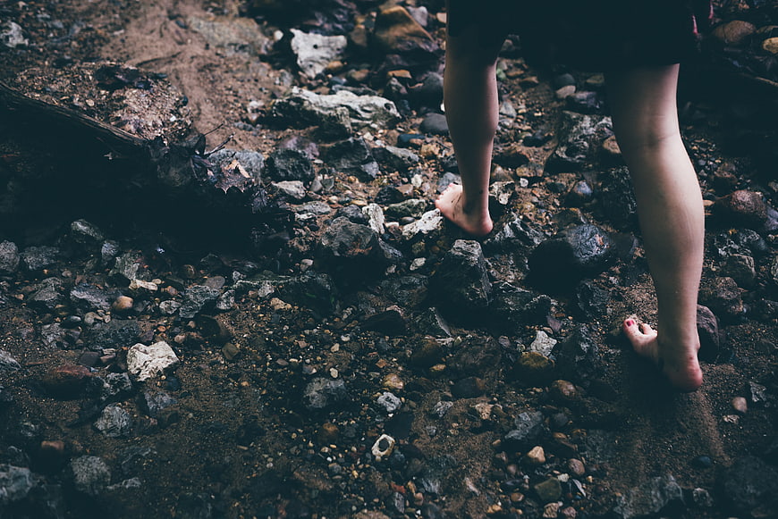 Barefoot Woman Walking on Rocky Trail in Nature